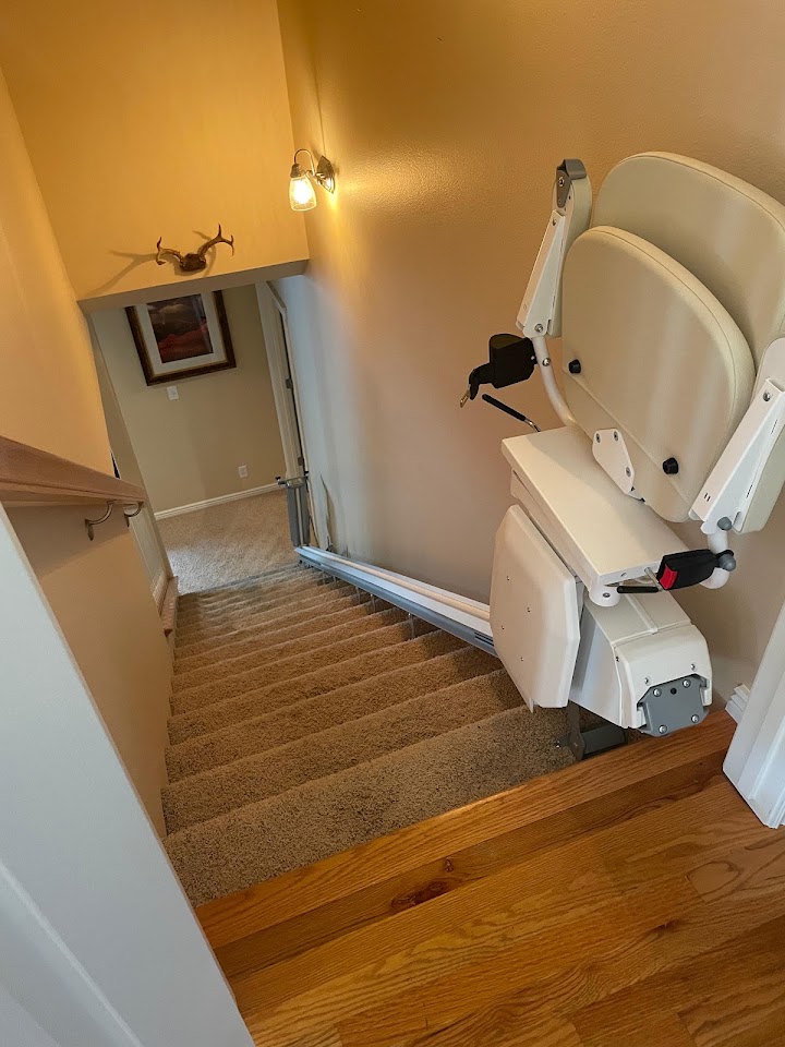 Straight stairlift with a folding rail installed on a staircase